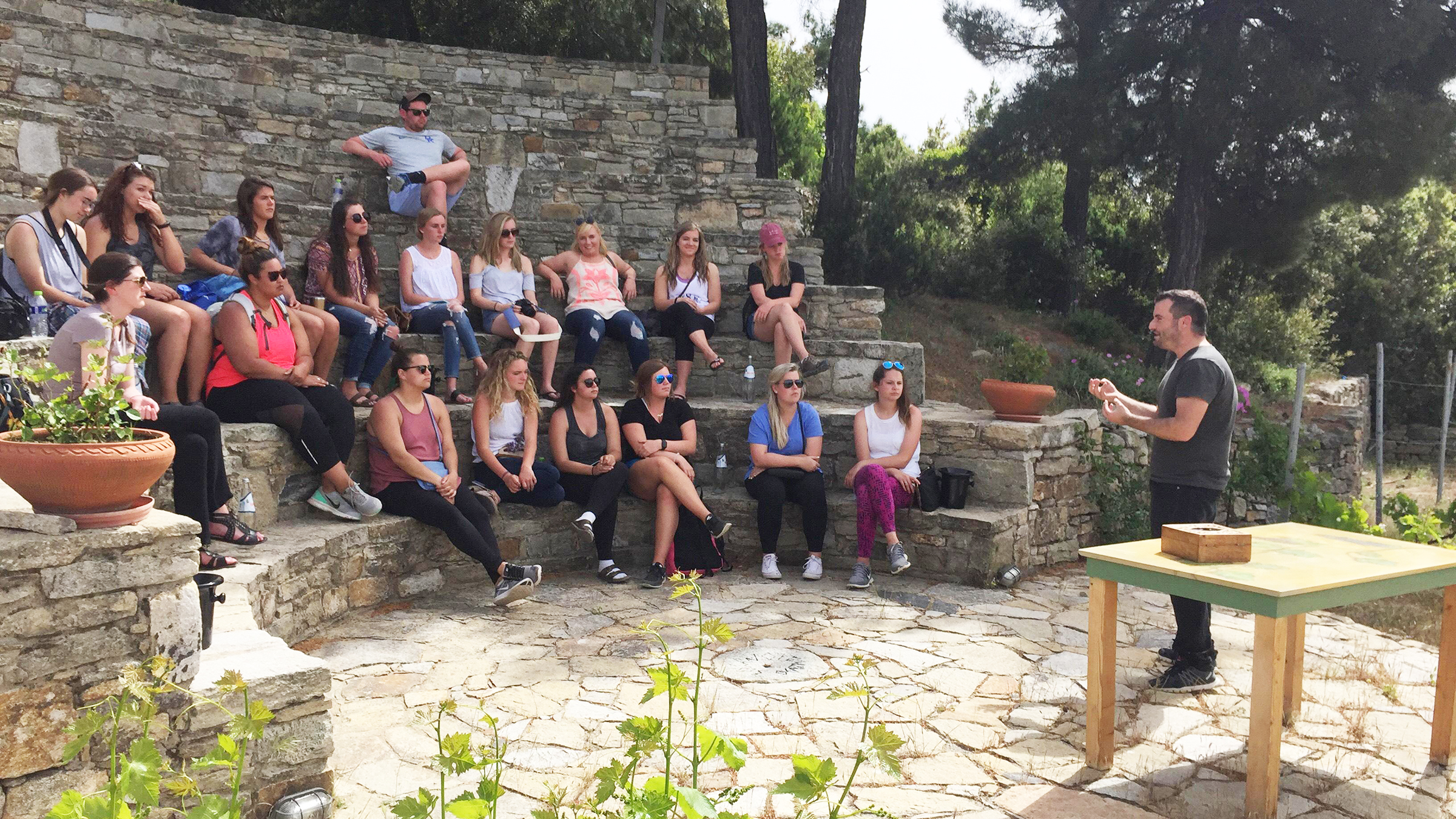 Students sit on cobblestone steps during a lecture on an education abroad trip.