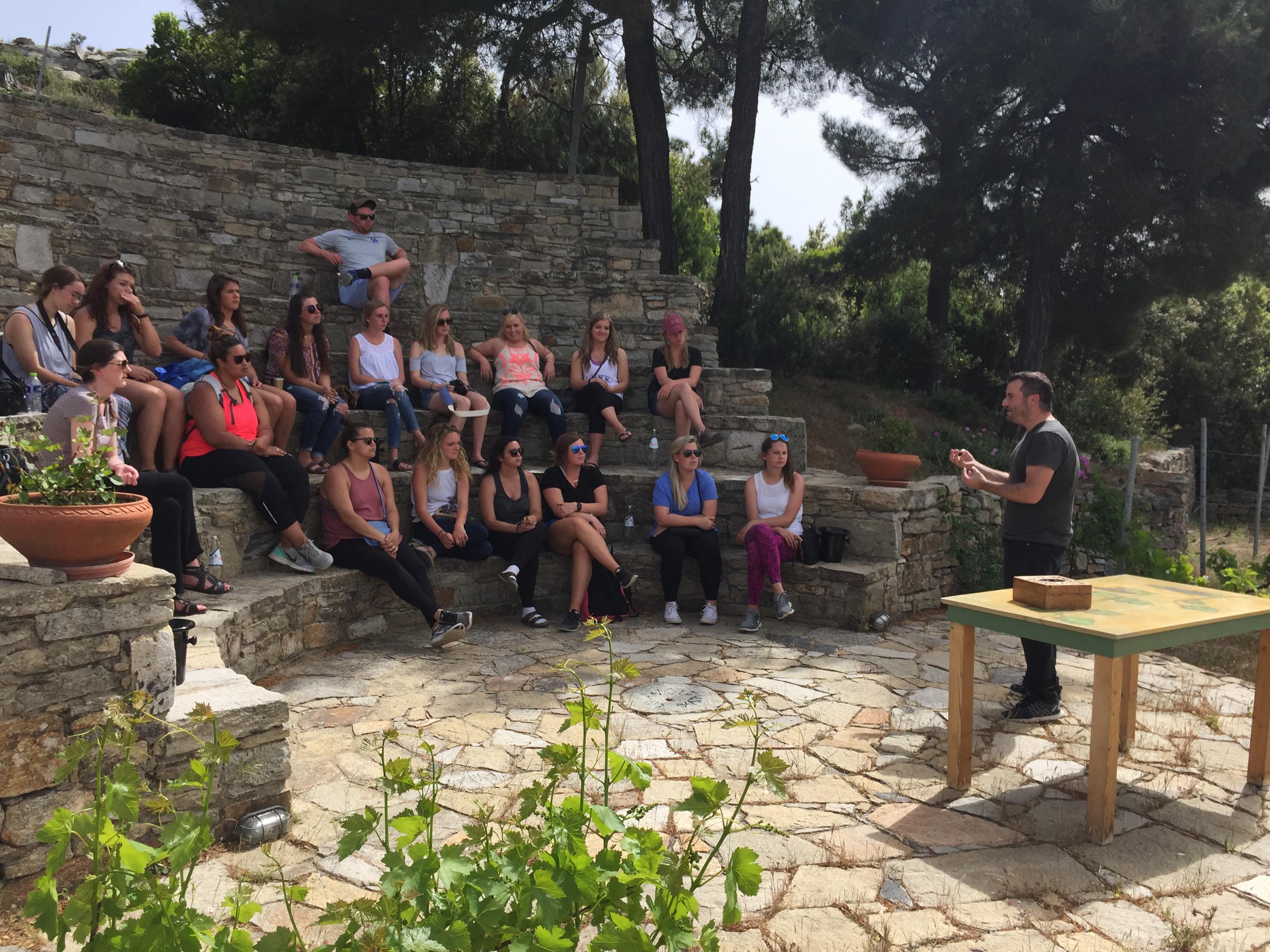 Students sitting on cobblestone steps during lecture on an education abroad trip